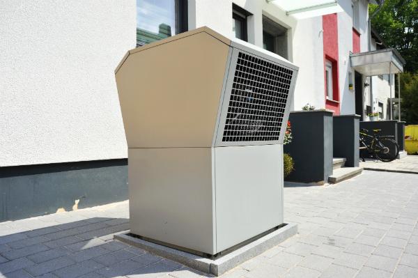 Luftwaermepumpe fuer Heizung und Warmwasser vor einem Niedrigenergiehaus