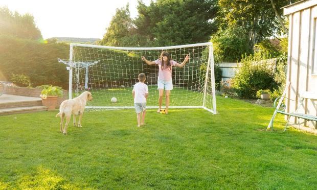 Familie-spielt-Fussball-im-Garten