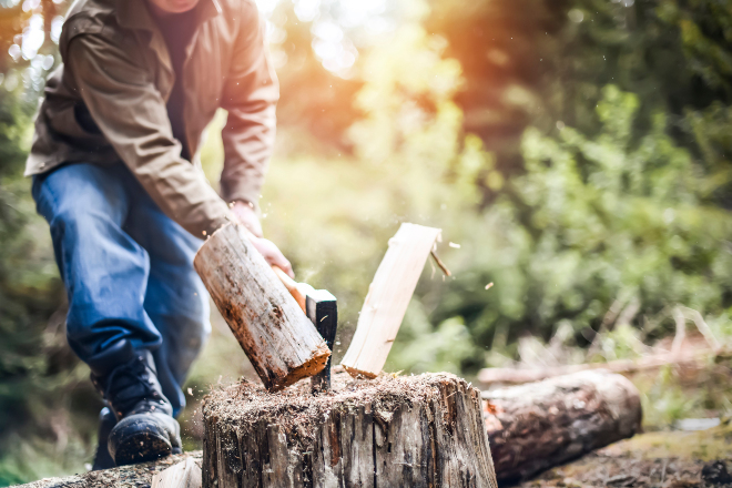 Bevor es ans Spalten geht, sollte Sie für Ihre Sicherheit sorgen Ein Mann spaltet ein Stück Holz
