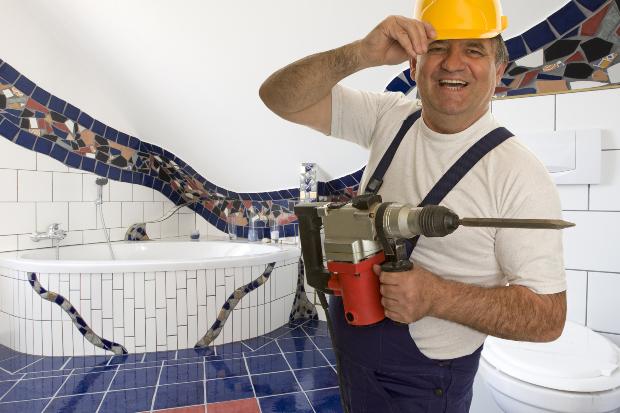 Fliesenbohren ist eine anspruchsvolle Angelegenheit Handwerker mit mit Spezialbohrgerät - Fliesen bohren im Bad
