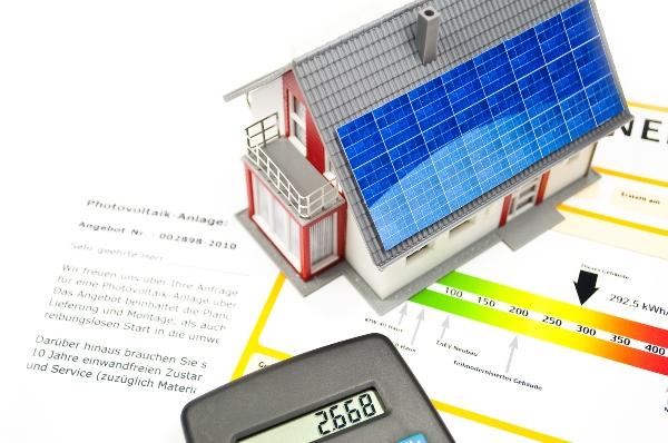 Haus mit Solarzellen, Taschenrechner und Energiepass