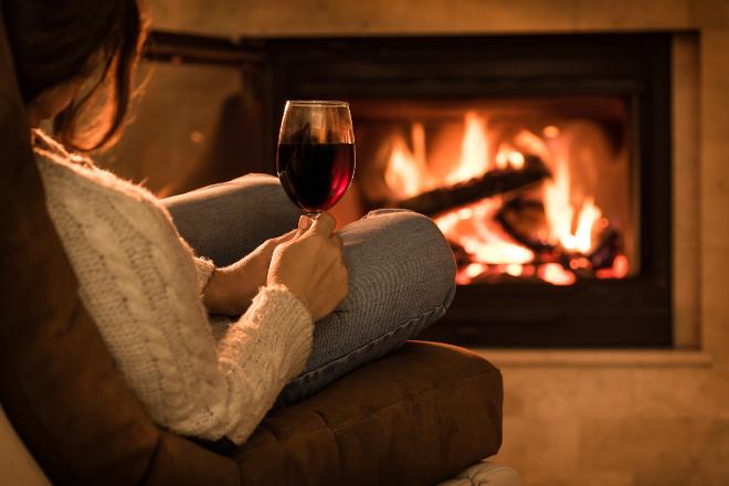 Frau im Sessel vor Kamin