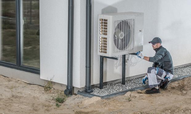 Ein Arbeiter montiert eine Wärmepumpe