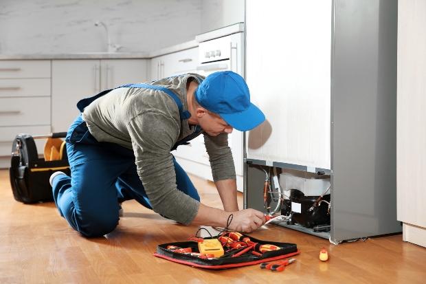 Mann repariert Kühlschrank - Prinzipumkehrung im Vergleich zur Luftwärmepumpe