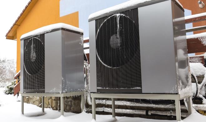 Gerade eine Luftwärmepumpe lässt sich in den meisten Altbauten realisieren Luftwärmepumpen vor Wohnhaus im Winter - Wärmepumpe nachrüsten im Altbau