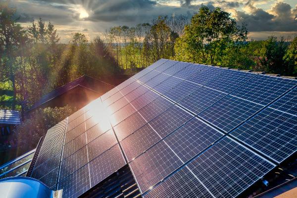 Auf die PV-Anlage eines Einfamilienhauses scheint die Sonnen zwischen Regenwolken hindurch