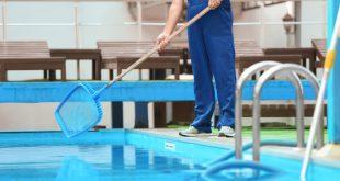 Mann bei der Poolreinigung mit einem Kescher