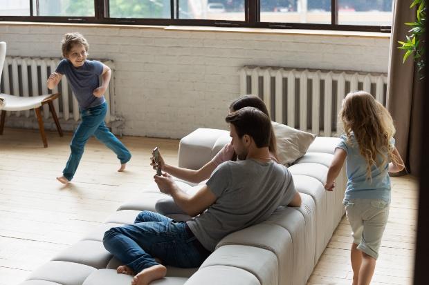 Junge Familie mit zwei Kindern im Wohnzimmer