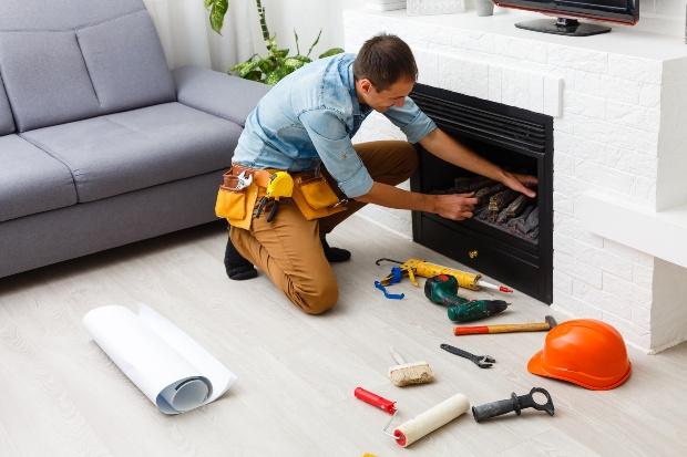 Handwerker arbeite an einem Kamin - Kachelofeneinsatz tauschen