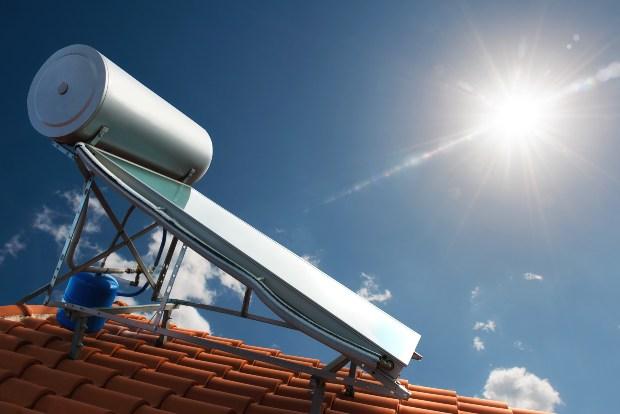 Auf einem Dach ist eine moderne Solarthermieanlage montiert Heizungsunterstützung