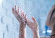 Frau in der Dusche - Warmwasserkosten senken