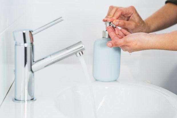 Jemand wäscht sich die Hände - Warmwasserkosten senken