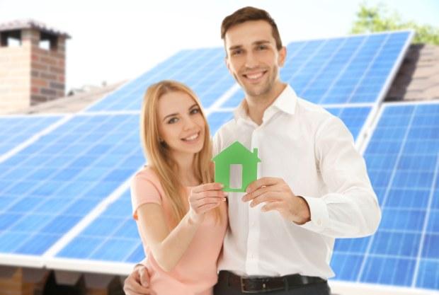 Junges Paar steht vor Solardach - BAFA-Förderung für Solarthermie 2022