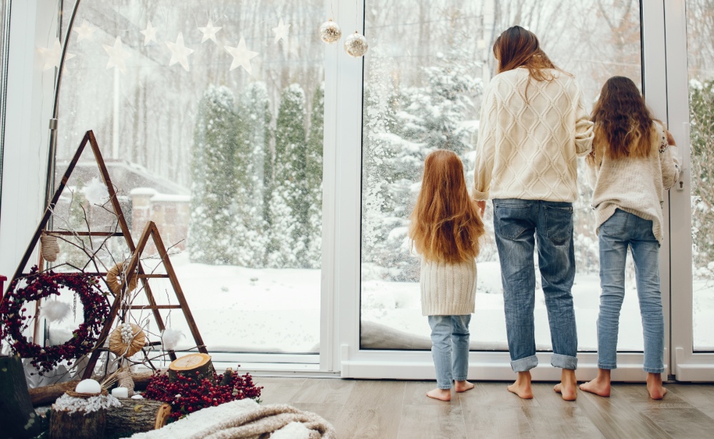 Mutter-mit-Töchtern-im-Winter-am-Fenster